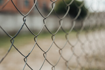 Fototapeta premium Selective focus of prison bars with copy space. Metal grid cage near pre-trial detention center. Despair concept. Jail iron fence. Imprisonment, custody, gaol, confinement. Criminal story and guilt.