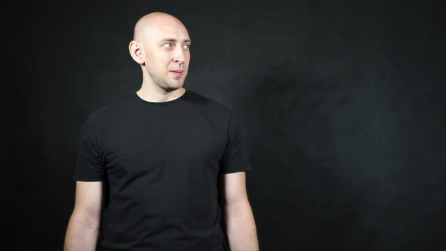 A bald European man in a black T-shirt.