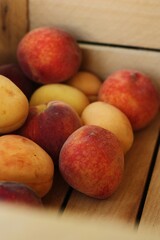 Ripe peaches and apricots in a wooden box