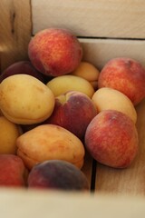 Ripe peaches and apricots in a wooden box