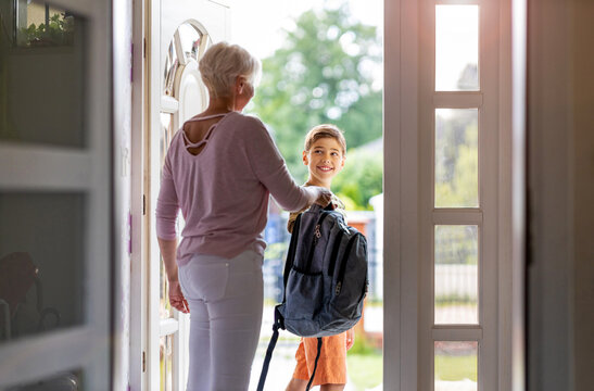 Mother and son with backpack in entrance hall

