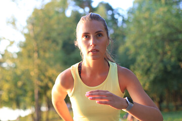Young woman in sports clothing running while exercising outdoors.