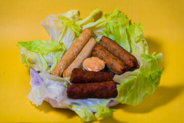 Seek kebabs with sausages on greens