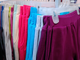 Soft Colorful Pants Hanging on the Rack For Sale at Clothing Store