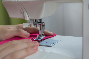 hands hold the fabric. machine sewing thread