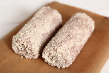 Uncooked meat roulade. Rolled meat with a filling of cheese and ham.