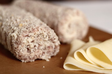 Uncooked meat roulade. Rolled meat with a filling of cheese and ham.