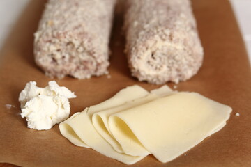 Fototapeta na wymiar Uncooked meat roulade. Rolled meat with a filling of cheese and ham.
