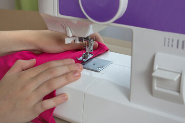 hands hold the fabric. machine sewing thread