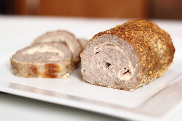 Meat roulade. Rolled meat with a filling of cheese and ham.