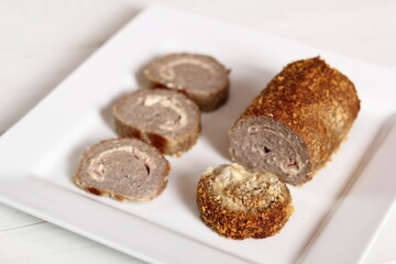 Meat roulade. Rolled meat with a filling of cheese and ham.
