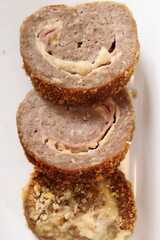 Meat roulade with salad on plate. Rolled meat with a filling of cheese and ham.