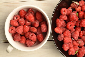 Juicy organic raspberries, close-up, on a white wooden table.