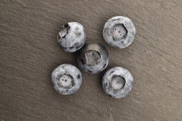 Ripe juicy organic blueberries, close-up, on a slate board.