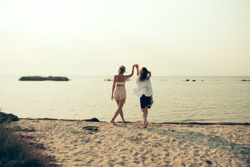 lesbian couple have fun on beach Beautiful women friends happy relax near sea when sunset in evening Lifestyle lesbian couple travel on beach concept.