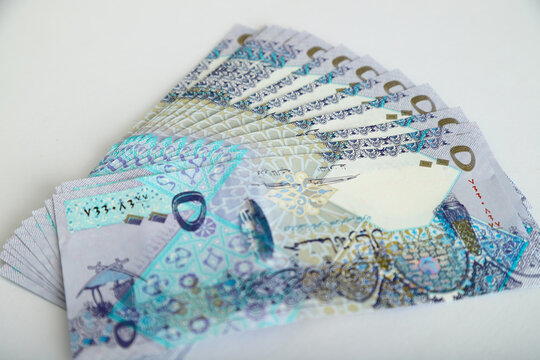 Doha, Qatar - May 03, 2020: Currencies and money exchange trading concepts. Qatari 500 ,100,50,10,5,1 Riyals Bank Note .& Coins ,Qatari Currency roll .