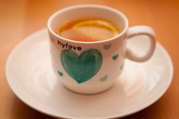 Tea cup on saucer with lemon on a wooden table