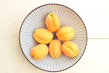 Ripe organic yellow apricot, close-up, on a wooden table.