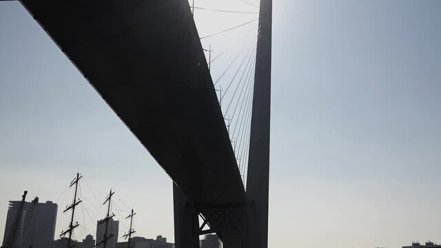 bottom view of huge bridge in the sun against the background of urban new buildings