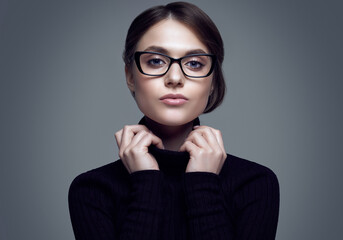 Cute student girl wearing black turtleneck sweater and stylish eyeglasses