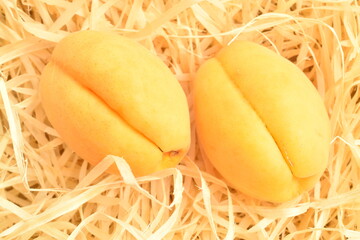Juicy organic apricots, close-up, on wood shavings.