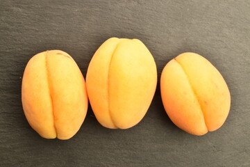 Juicy organic apricots, close-up, on a slate board.