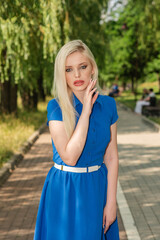 Portrait of a beautiful blonde girl outdoors in summer