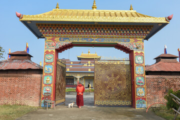 Monk in front of the entrance door at the monastic zone of Lumbini on Nepal
