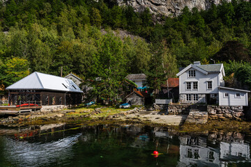 Fototapeta na wymiar Old wooden buildings by the waters at Geiranger Norway