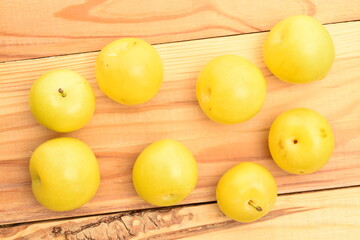 Ripe yellow plum, close-up, on a wooden table.