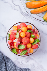 Fototapeta na wymiar Fruit salad with melon cantaloupe, watermelon and prosciutto