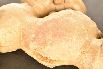 Fresh ginger root, close-up, on a slate serving board.