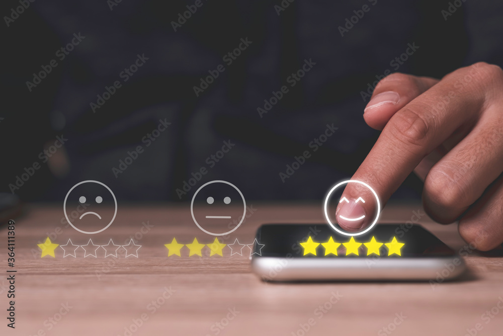 Aufkleber hand touch on mobile phone to add five yellow stars to customer evaluates products and services. cus
