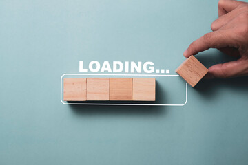 Hand putting wooden cube on virtual infographic rectangle block with loading wording. Job and...