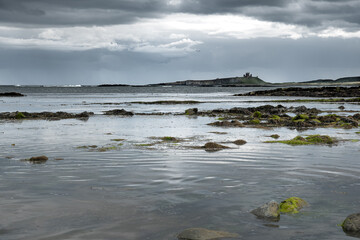 The tide has turned at Low Newton-by-the-Sea but clouds are heavy before the rain on a warm summers day.