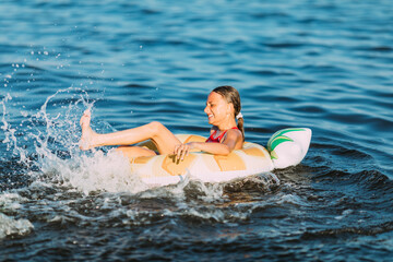 Happy child on an inflatable circle floating on the sea, Summer holidays with children. Swimming equipment and clothing for children. A little girl is floating on an inflatable circle