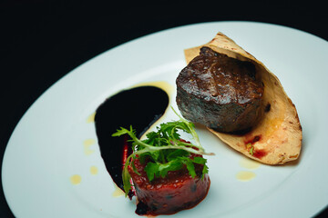 Steak, tomato sauce and pita bread on the white plate, close up