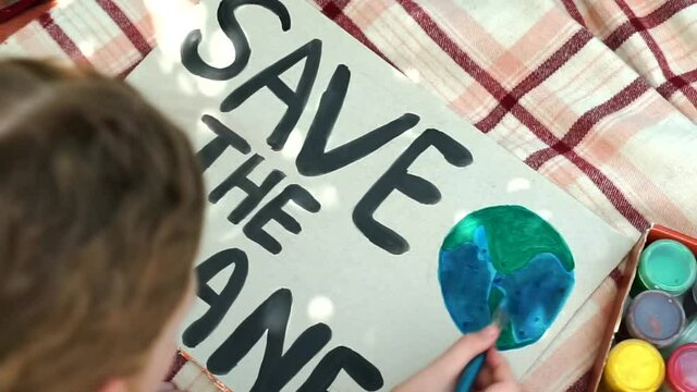 child painting colorful save the planet poster. young kid girl volunteer drawing a banner to fight against pollution, global warming, earth day. Educational activity to save nature.top view