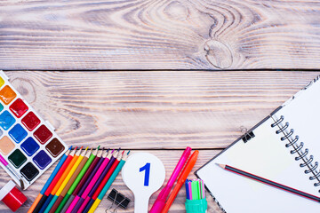 School supplies on a wooden table with space for text, top view