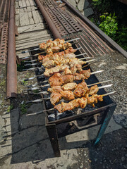 Delicious shish kebab is prepared on an old black grill in Kamen-na-Obi, Altai, Russia. Vertical.