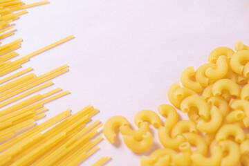 ピンクの背景のショートパスタとロングパスタ