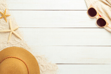 Summer background with beach accessories - straw hat, sunglasses on white wood table background top view with copy space.