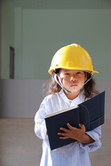 Education concept, Asia kid girl posing in engineers dress with holding book.