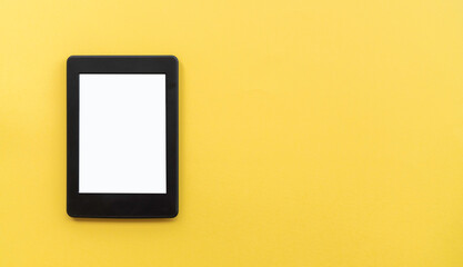 A modern black electronic book with a white blank empty screen on yellow background with empty space