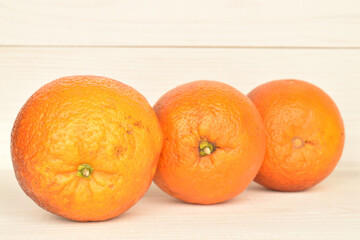 Juicy organic oranges, close-up, on a wooden table.