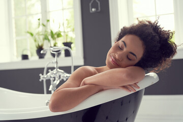 Calm young woman relaxing in hot bath
