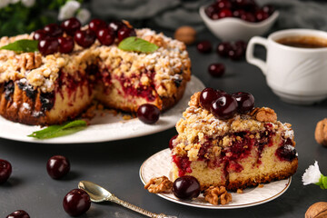 Piece homemade cherry pie with shtreisel and walnuts on white plate on a dark concrete background, Closeup