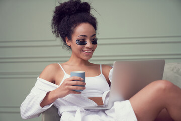 Happy young woman relaxing with laptop at home