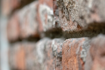 Old broken red brick wall in close-up