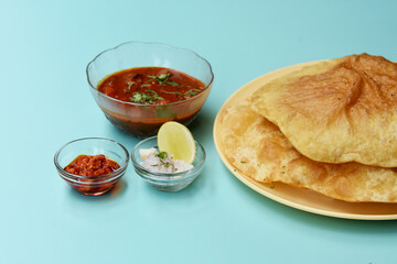 Indian dish spicy Chick Peas curry also known as Chole Bhatura and Chana Masala or Chole or Chickpeas Masala curry,traditional north indian lunch served with fried puri or flatbreads,selective focus
